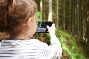 niña haciendo foto en el bosque con el móvil